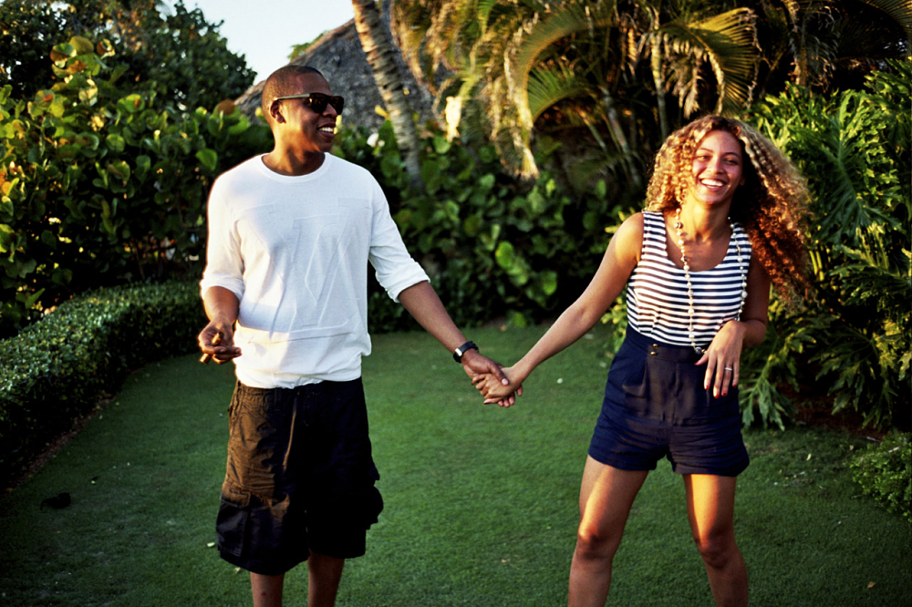 Le rappeur Jay-Z et sa femme Beyoncé se tenant la main dans un jardin tropical.