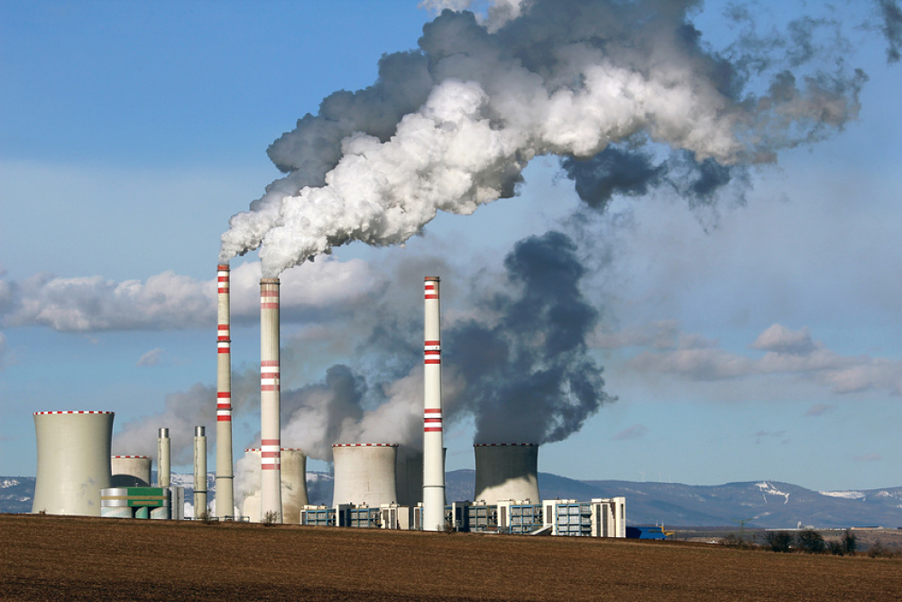 Fumée s'échappant de cheminées d'usine placée à côté d'une terre