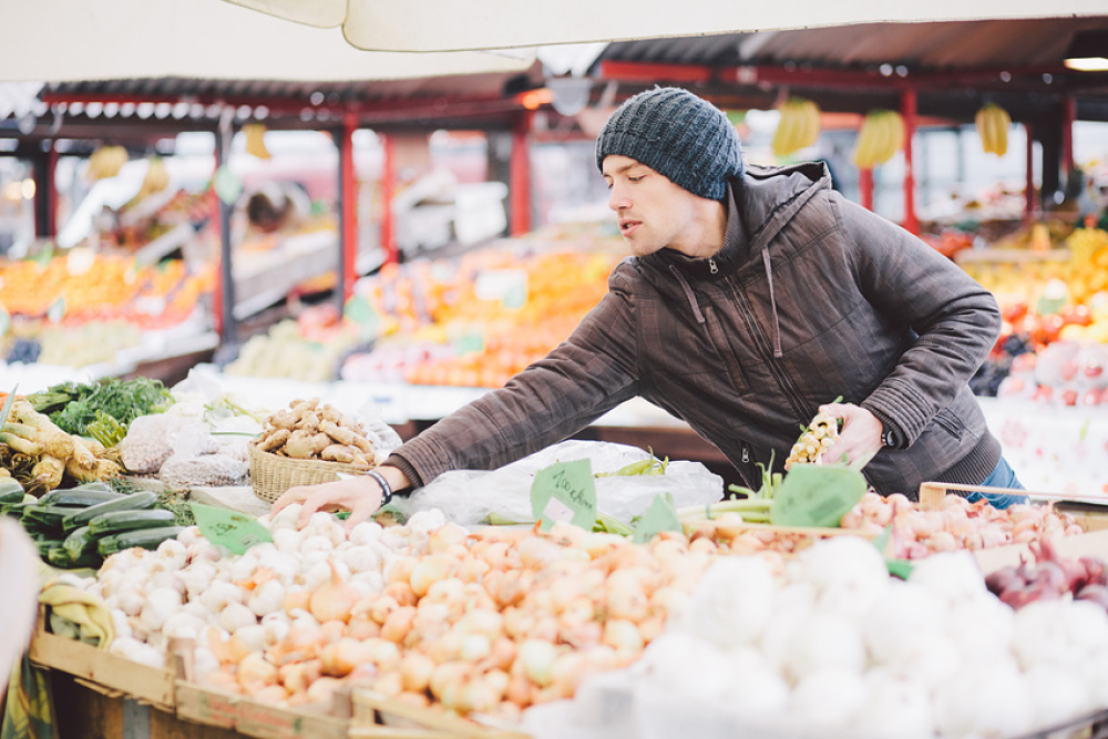 Maraîcher vendant ses légumes derrière son étal