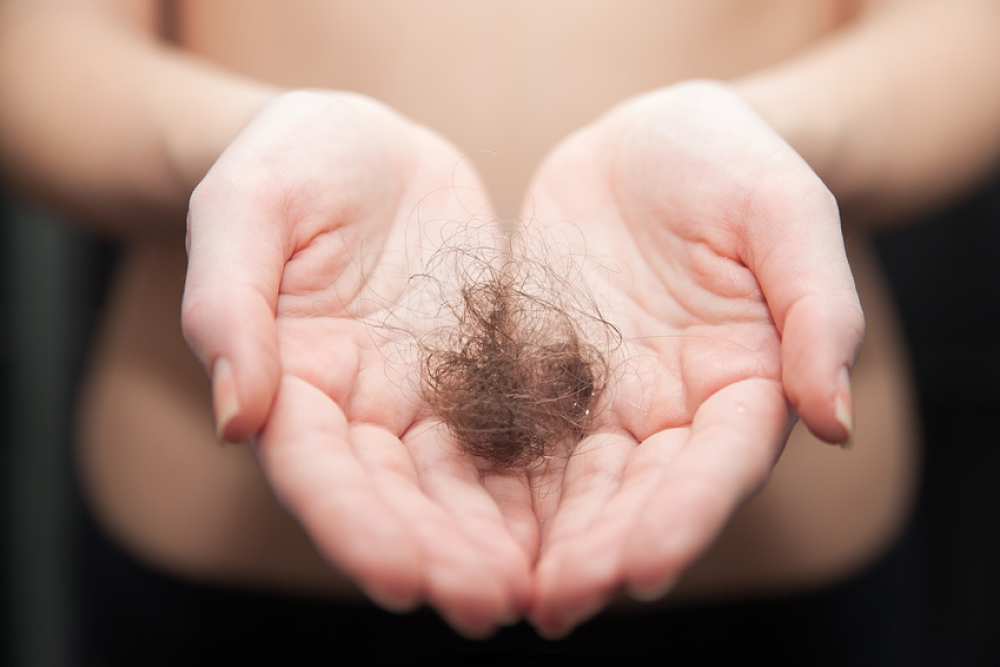 Femme tenant un amas de cheveux au creux de ses mains