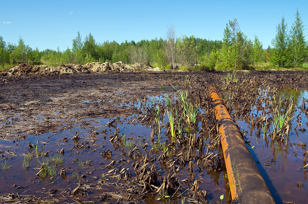 Paysage de campagne pollué par du pétrole échappé d'un oléoduc