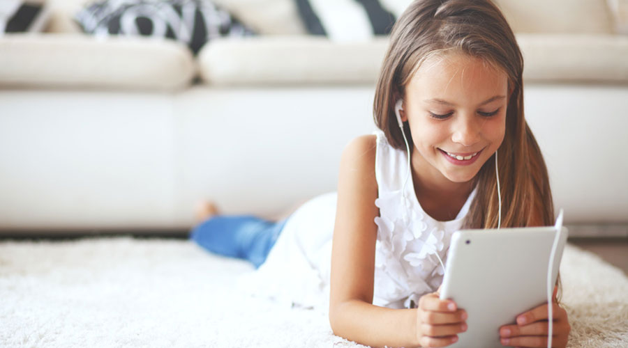 Une petite fille devant une tablette