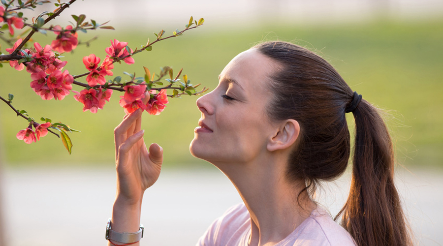 Femme sentant une fleur